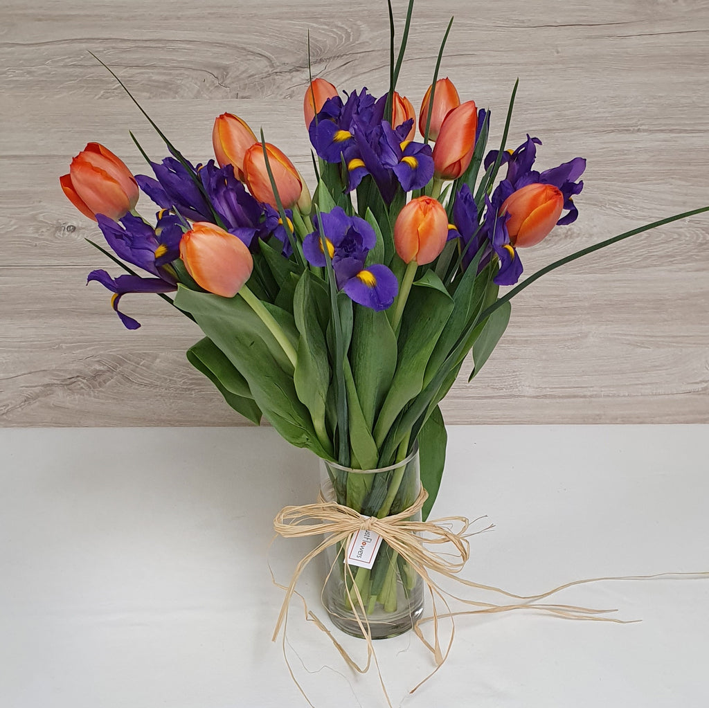 Florero de Iris y Tulipanes – Azul y Color en Arreglo con Florero de Vidrio